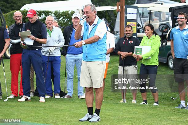 Joerg Wontorra reacts after he hits a tee shot during the 'RTL - Wir helfen Kindern' Golf Charity 2015 tournament at Golf Club Oberberg on August 24,...
