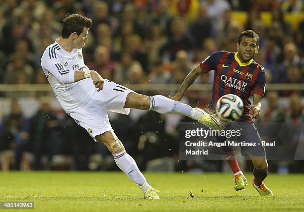 Gareth Bale of Real Madrid shoots on goal under pressure from Daniel Alves of FC Barcelona during the Copa del Rey Final between Real Madrid and...