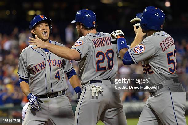 Wilmer Flores of the New York Mets celebrates his three-run home run with Daniel Murphy and Yoenis Cespedes in the fifth inning against the...