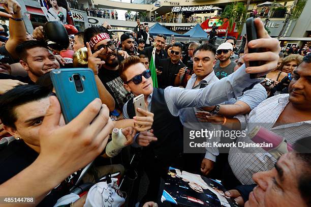 Boxer Canelo Alvarez poses with fans after a news conference to announce his next fight against current WBC champion Miguel Cotto August 24 in Los...