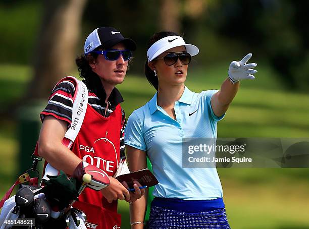 Michelle Wie discusses a shot with caddie Duncan French during the first round of the LPGA LOTTE Championship Presented by J Golf on April 16, 2014...