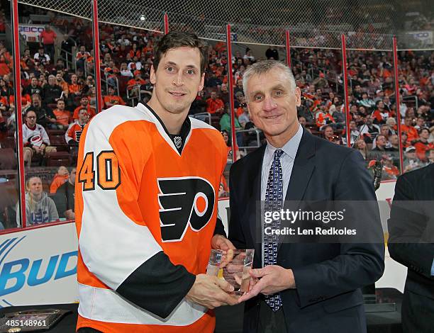 General Manager Paul Holmgren presents Vincent Lecavalier of the Philadelphia Flyers with his award from Commissioner Gary Bettmen for his 400 NHL...