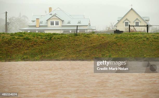 House downstream of Jerrara dam is protected by river banks during flooding effecting the area on August 25, 2015 in Kiama, Australia. Residents...