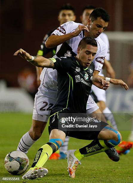 Mauro Cejas, of Santos Laguna, and Jorge Alberto Ortiz, of Lanus, vie for the ball during a match between Lanus and Santos Laguna as part of Copa...