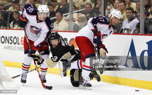 Brandon Dubinsky and Matt Calvert of the Columbus Blue Jackets battle behind the net against Olli Maatta of the Pittsburgh Penguins in Game One of...