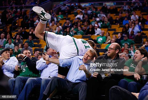 Kelly Olynyk of the Boston Celtics runs over the first row of fans in their seats in the second half against the Washington Wizards during the game...