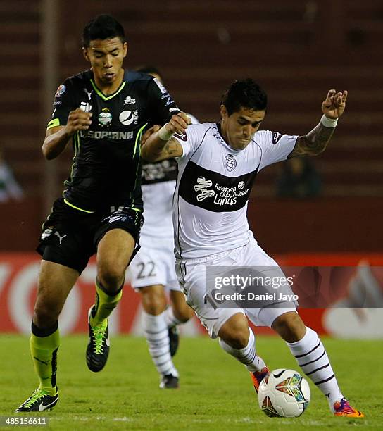 Sergio Ceballos, of Santos Laguna, and Victor Hugo Ayala, of Lanus, fight for the ball during a match between Lanus and Santos Laguna as part of Copa...