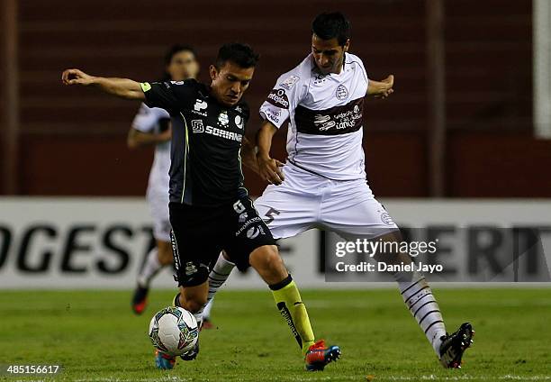 Juan Rodriguez, of Santos Laguna, and Diego Hernan Gonzalez , of Lanus, fight for the ball during a match between Lanus and Santos Laguna as part of...