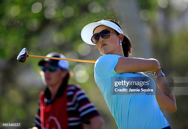 Michelle Wie hits her first shot on the 6th hole as caddie Duncan French watches during the first round of the LPGA LOTTE Championship Presented by J...