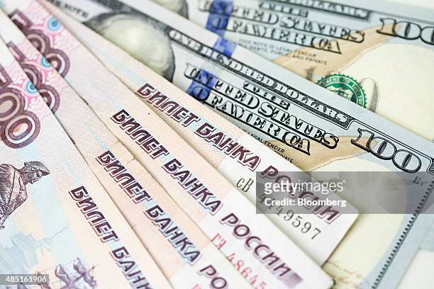 Russian Ruble notes sit on top of a pile of American Dollar bills in this arranged photograph in London, U.K., on Monday, Aug. 24, 2015. The plunge...