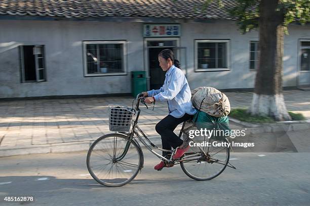 Woman rides bike on street on August 22, 2015 in Nampo, North Korea. North and South Korea today came to an agreement to ease tensions following an...