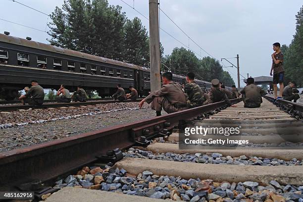 Korean People's Army soldier rest on the rails during a train journey amidst tension between North Korea and South on August 21 North Korea. North...