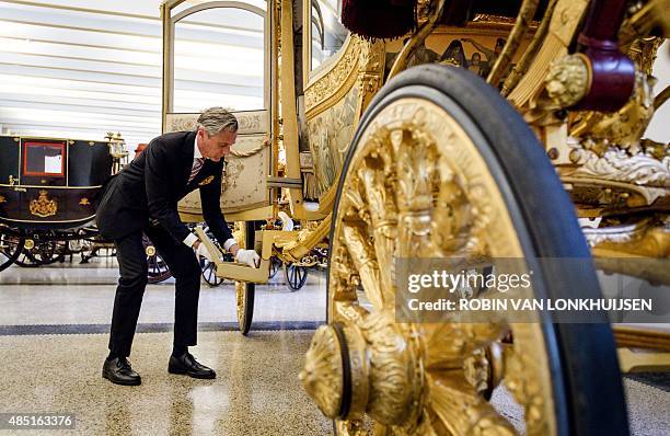 Curator Paul Rem pulls out the folding steps of the Golden Carriage in the museum at the Palace Het Loo in Apeldoorn, the Netherlands, on August 25,...