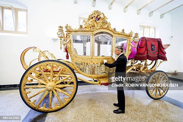 Curator Paul Rem stands next to the Golden Carriage in the museum at the Palace Het Loo in Apeldoorn, the Netherlands, on August 25, 2015. The Golden...
