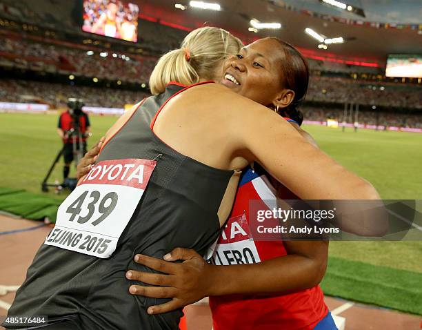 Denia Caballero of Cuba is congratulated by Nadine Muller of Germany after winning gold in the Women's Discus final during day four of the 15th IAAF...