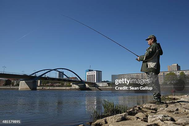 Man fishes in the Oder River near the bridge that connects the Polish town of Slubice and the German city of Frankfurt an der Oder at the...