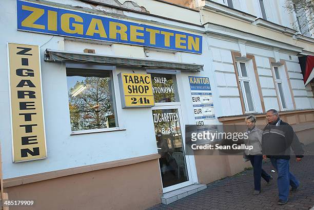 People walk past a shop that seels cigarettes that are cheaper than in Germany near the German-Polish border on April 16, 2014 in Slubice, Poland....