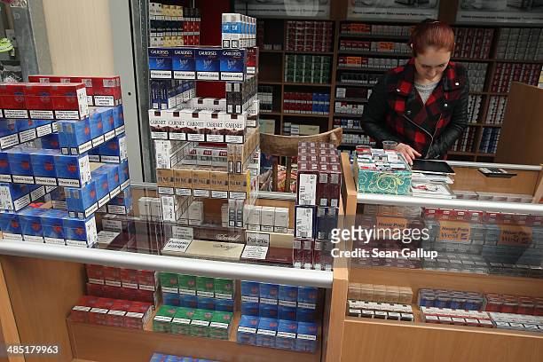 Woman waits for shoppers at a stand selling cigarettes that are cheaper than in Germany at an outdoor market near the German-Polish border on April...