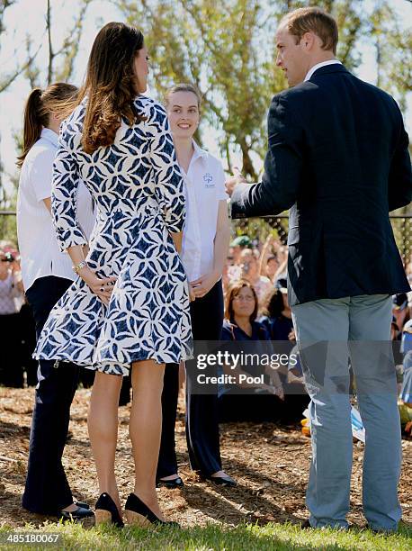 Catherine, Duchess of Cambridge holds onto her dress as the wind blows as the Duke and Duchess of Cambridge meet Winmalee Girl Guides at Winmalee...