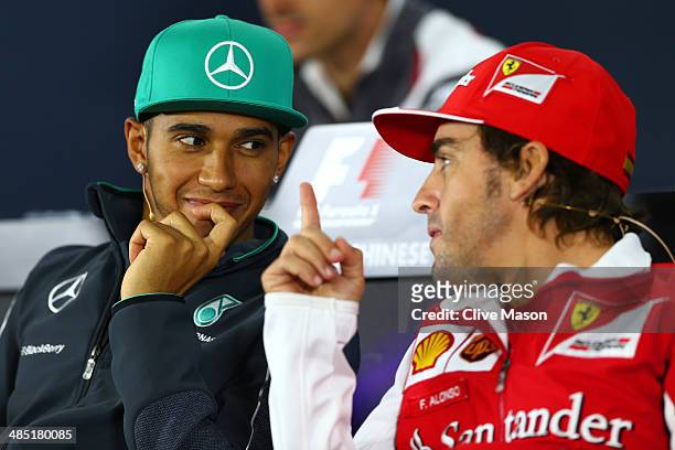 Lewis Hamilton of Great Britain and Mercedes GP speaks with Fernando Alonso of Spain and Ferrari during a press conference ahead of the Chinese...