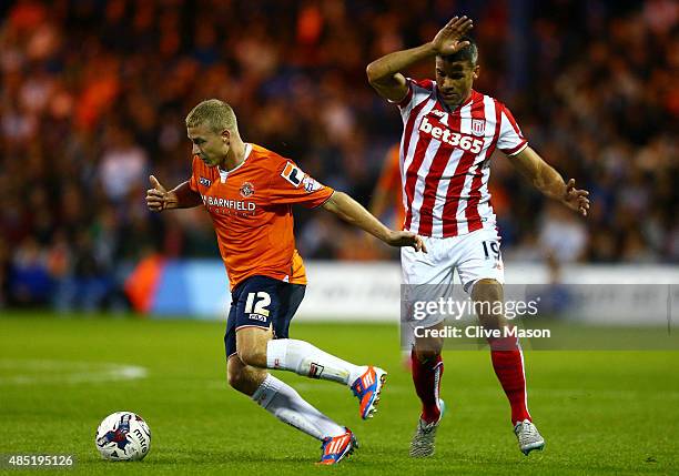 Scott Griffiths of Luton Town is closed down by Jonathan Walters of Stoke City during the Capital One Cup second round match between Luton Town and...