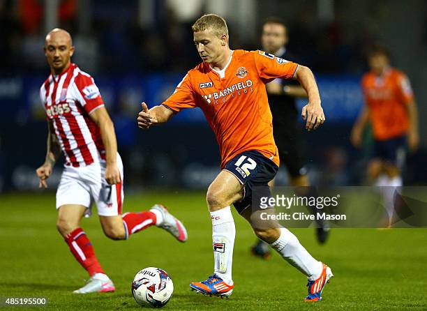 Scott Griffiths of Luton Town is closed down by Stephen Ireland of Stoke City during the Capital One Cup second round match between Luton Town and...