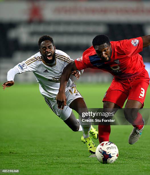 Swansea player Nathan Dyer is challenged by Femi Ilesanmi of York during the Capital One Cup Second Round match between Swansea City and York City at...
