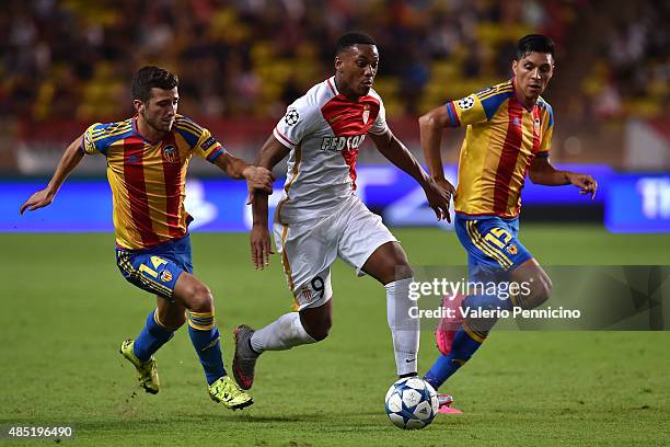 Anthony Martial of Monaco is challenged by Jose Gaya and Enzo Perez of Valencia during the UEFA Champions League qualifying round play off second leg...