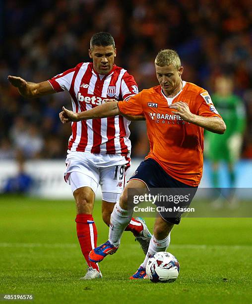 Scott Griffiths of Luton Town is closed down by Jonathan Walters of Stoke City during the Capital One Cup second round match between Luton Town and...