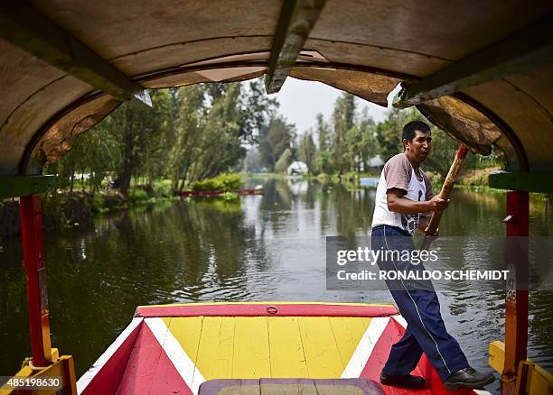 Rower is seen on board a moored "trajinera" -traditional flat-bottomed river boat- as he waits for tourists at Xochimilco natural reserve in Mexico...