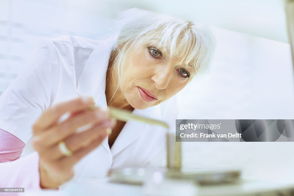 Female pharmacist weighing medicines for prescription