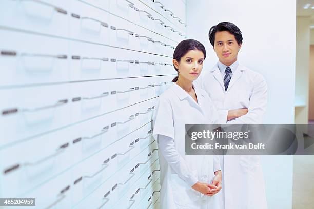 portrait of male and female pharmacists in pharmacy - werk in uitvoering stockfoto's en -beelden