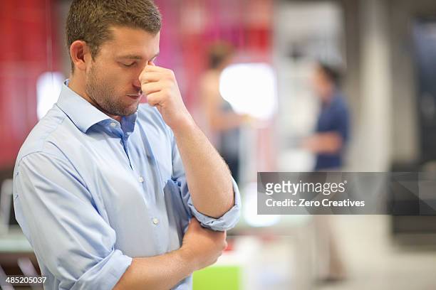 young businessman looking stressed in office - miscarriage stock pictures, royalty-free photos & images
