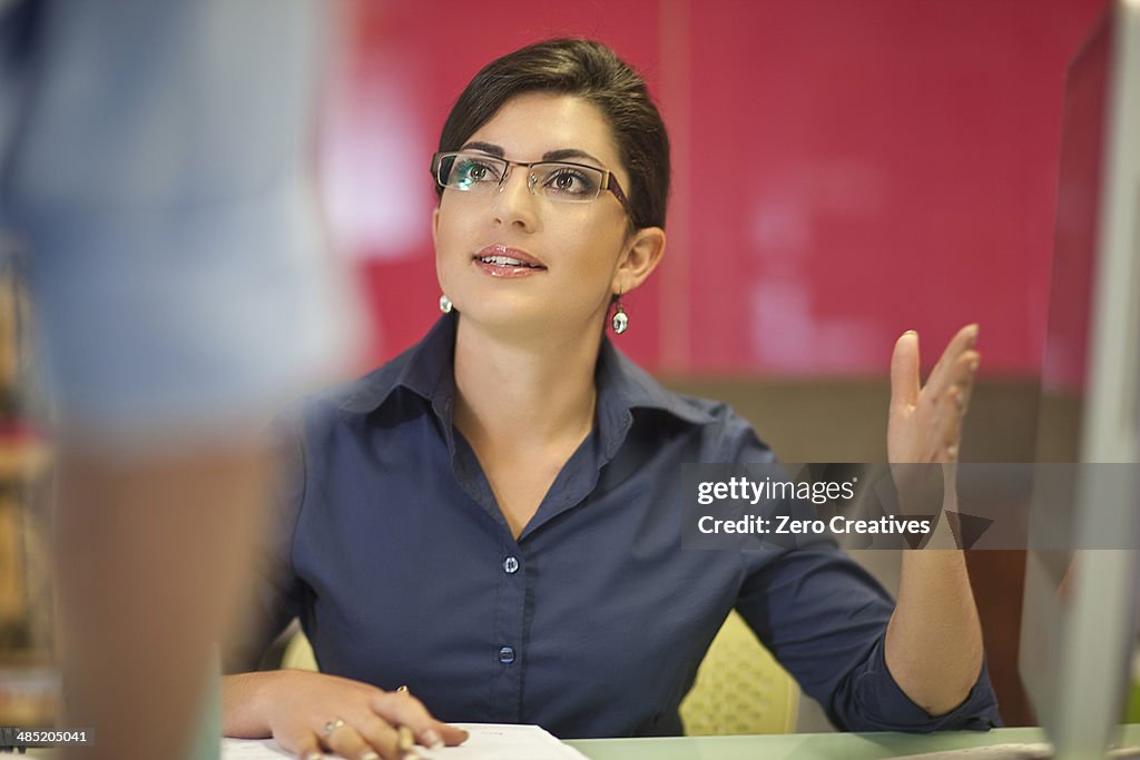 Young businesswoman advising colleague in office