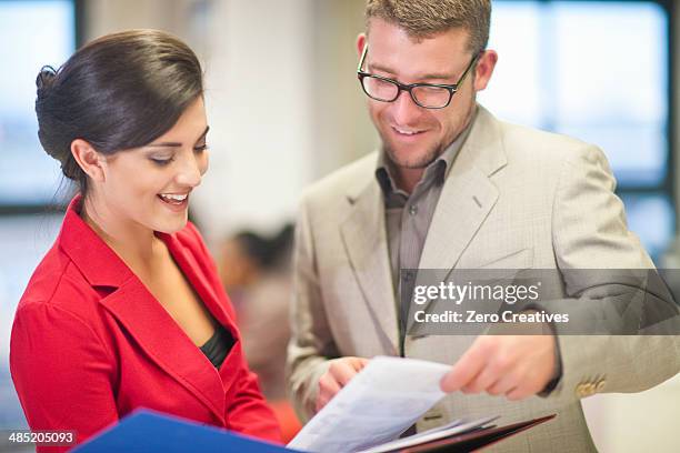 young businesswoman presenting ideas to colleague - business woman in red suit jacket stock pictures, royalty-free photos & images