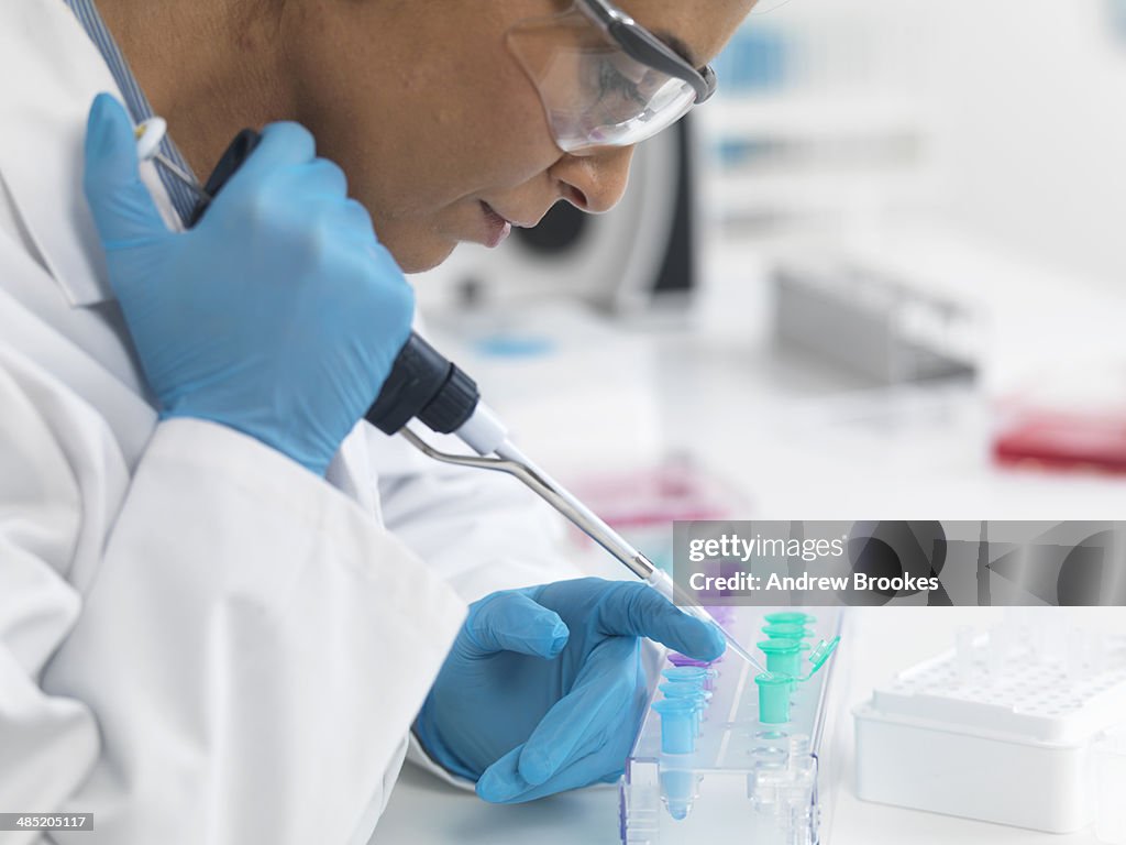 Female scientist pipetting DNA samples for testing