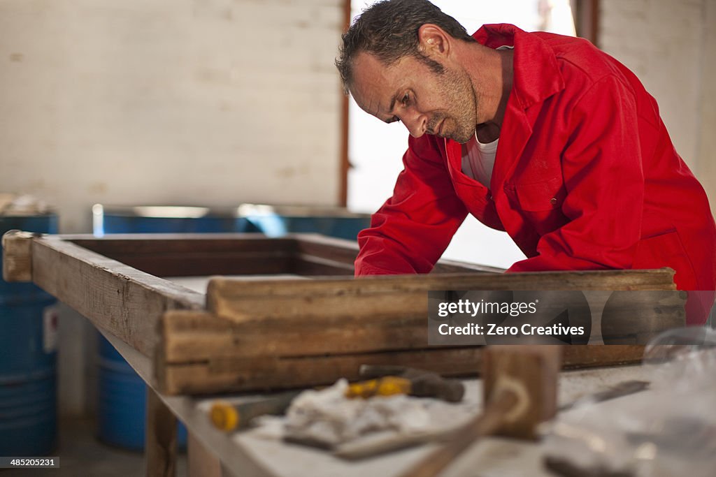 Carpenter working on wooden frame