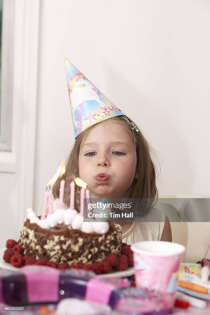 Girl blowing out candles on her birthday cake