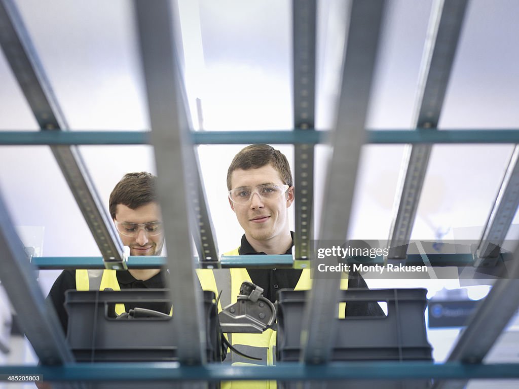Apprentices on production line picking parts