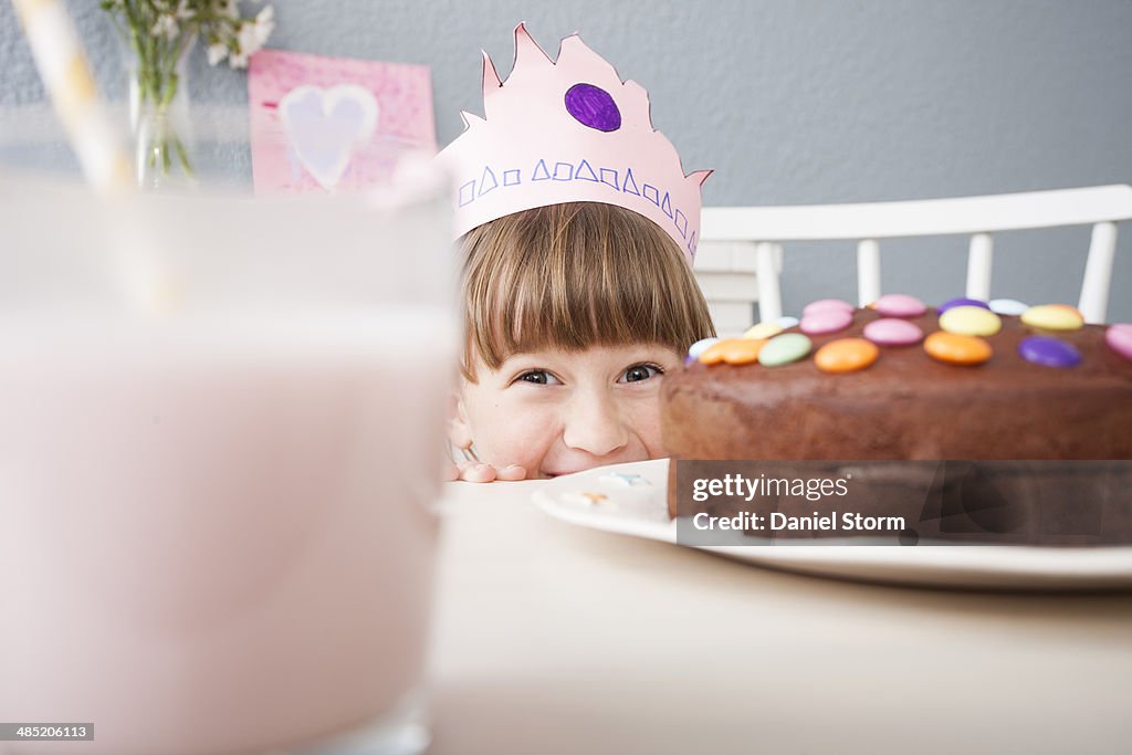Girl hiding behind cake