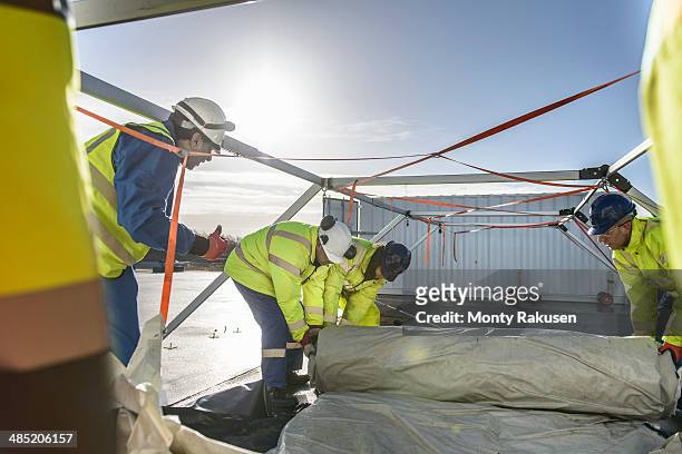 emergency response team workers erecting tent control centre - heysham stock pictures, royalty-free photos & images