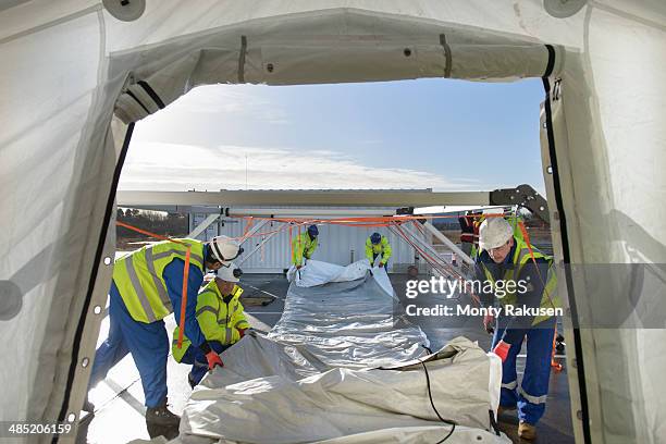 emergency response team workers erecting tent control centre - emergency response stock pictures, royalty-free photos & images