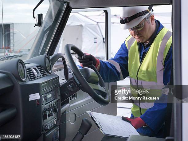 emergency response team worker looking at notes in four wheel drive vehicle - heysham stock pictures, royalty-free photos & images