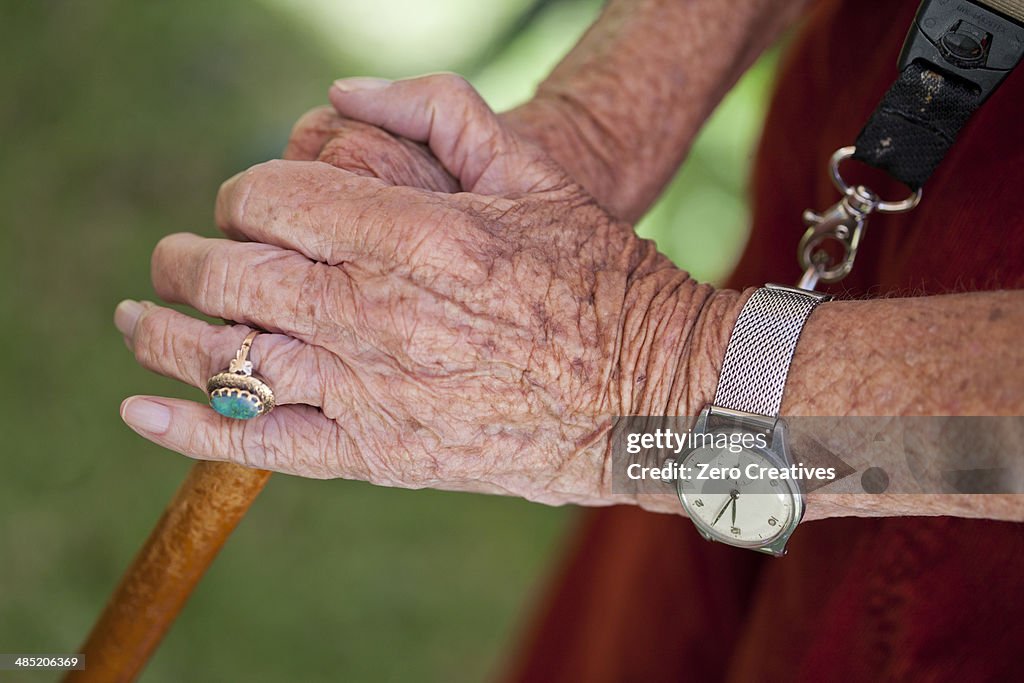 Close up of senior woman's hands holding walking stick