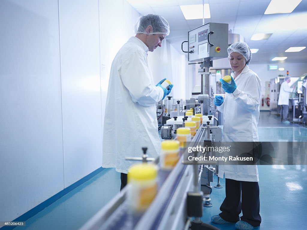 Workers inspecting packaging in pharmaceutical factory