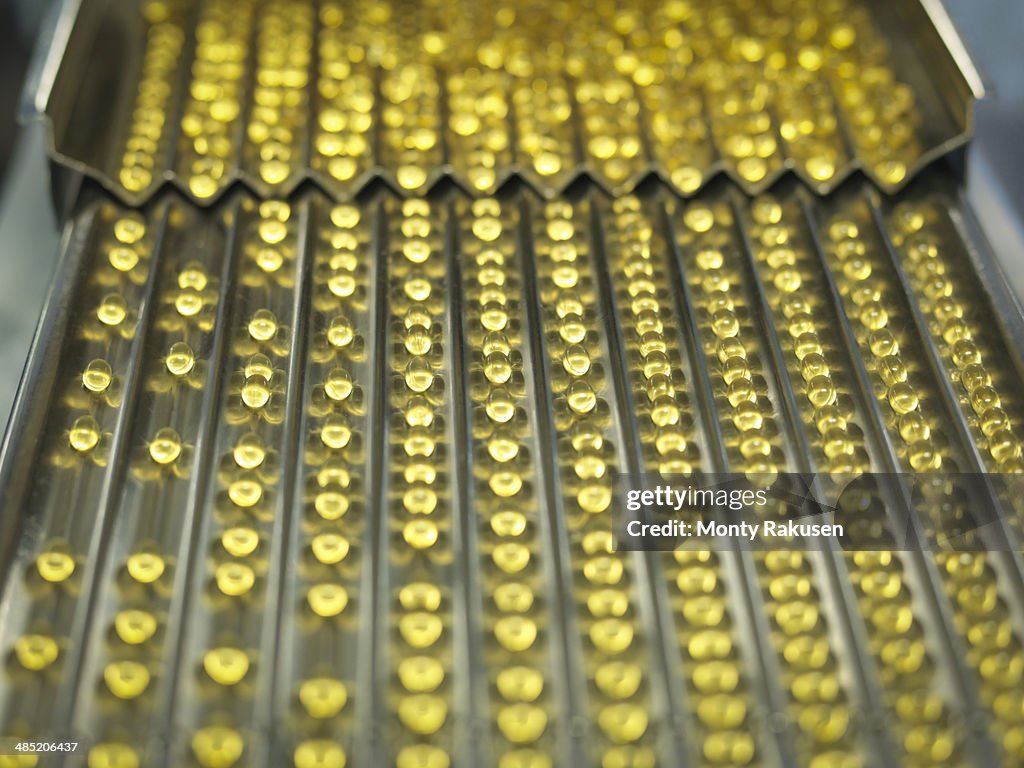 Rows of vitamin capsules in pharmaceutical factory