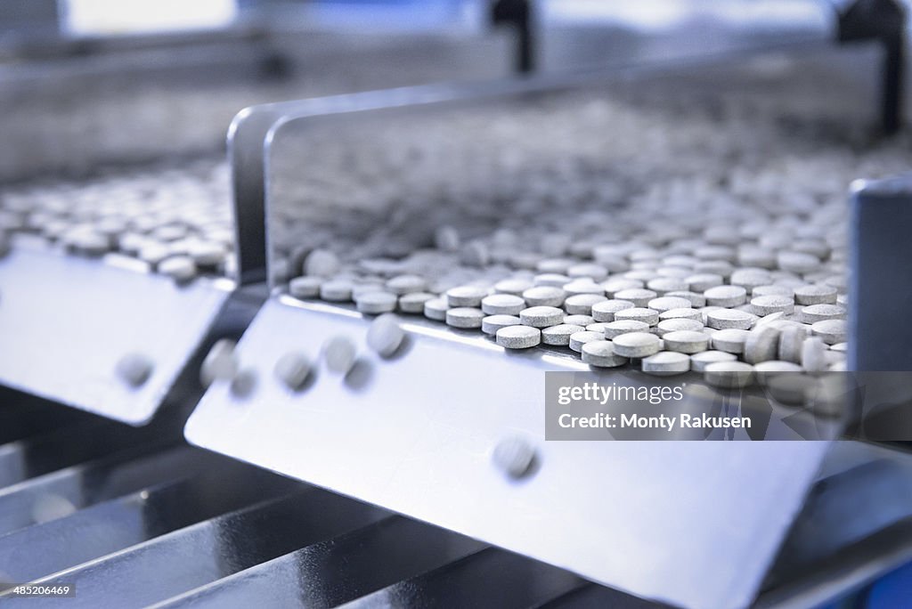 Close up of tablets in packing machine in pharmaceutical factory