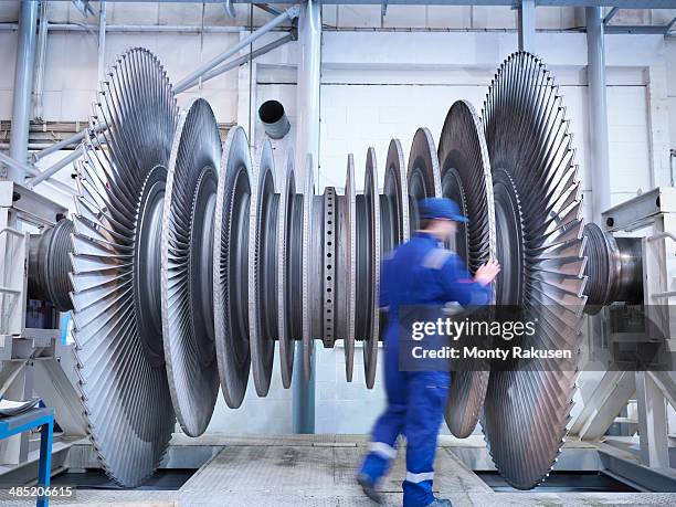 engineer inspecting steam turbine blades in repair bay of workshop - worker inspecting steel foto e immagini stock