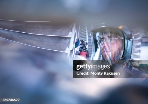 Engineer repairing steam turbine blade with grinder in workshop Engineer repairing steam turbine blade with grinder in workshop