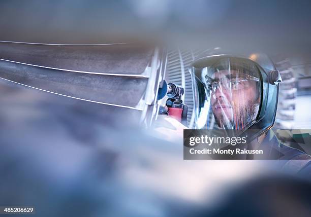 engineer repairing steam turbine blade with grinder in workshop - turbine stockfoto's en -beelden
